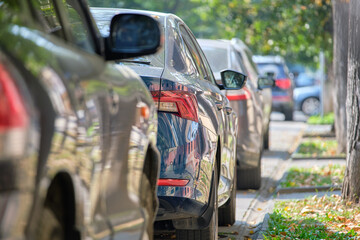 City traffic with cars parked in line on street side.