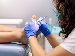 Female podiatrist doing chiropody in her podiatry clinic. Selective focus