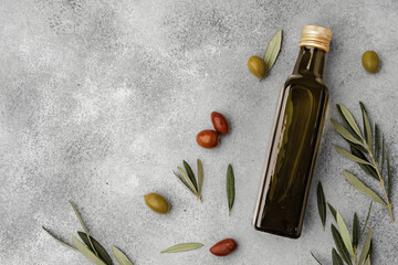 Glass bottle with olive oil on gray background - obrazy, fototapety, plakaty