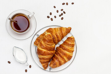 Fresh croissants, cream and cup of coffee.
