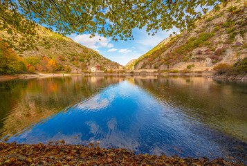 Villalago (Abruzzo, Italy) - A view of medieval village in province of L'Aquila, situated in the gorges of Sagittarius, with Lago San Domenico lake, bridge and sanctuary. Here during autumn foliage