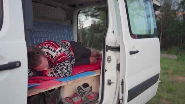 Norwegian Guy Sleeping On A Campervan Near The Mountains At Daytime. Static