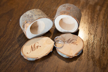 two wedding rings on tree branch boxes open decoration on wooden table