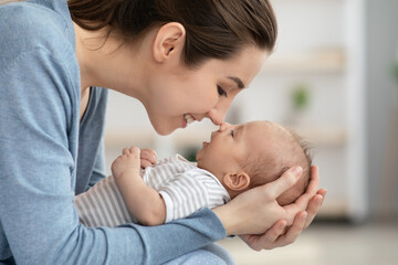 Nose To Nose. Young Mother Playing With Her Newborn Baby At Home