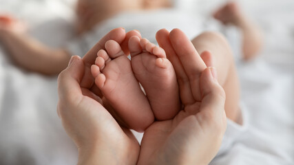 Closeup Shot Of Tiny Newborn Baby Feet In Mother's Hands