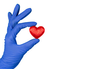 Doctors hand in a glove holds a heart on a white background isolated with copy space. world heart day, world blood donor