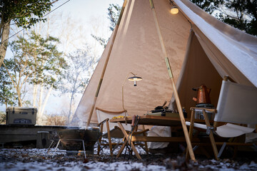 白いテントで冬キャンプを楽しむ風景