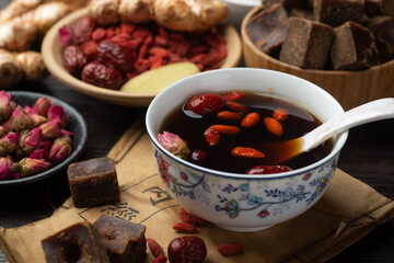 Brown sugar ginger jujube tea and Chinese classical medical books on the table