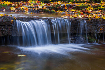Fototapeta na wymiar Beautiful small waterfall on a mountain stream
