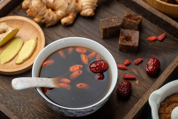 Brown sugar ginger jujube tea and Chinese classical medical books on the table