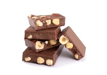 Pieces of chocolate bar with hazelnuts stacked on white background.