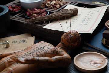 Ancient Chinese medicine books and herbs on the table.