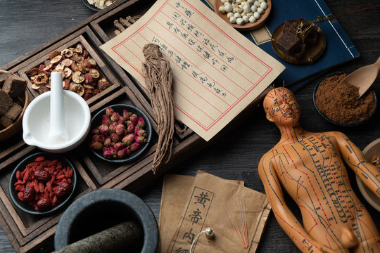 Acupuncture models and medical books are on the table. Acupuncture is a traditional Chinese medical method