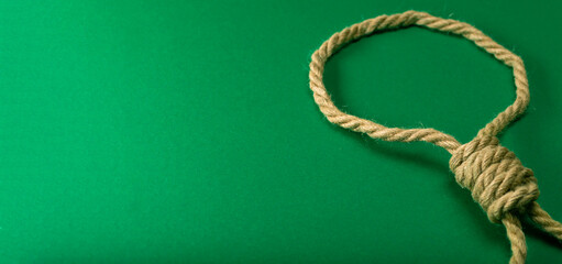 Thick rope tied in a noose on a green felt table, addicted to gambling