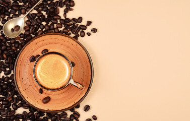 Realistic top view of black cup of espresso view from above, pastel peach color background. Cup with coffee crema and coffee beans.Template with copy space for your text.