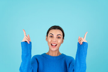 Beauty portrait of a young woman in a blue knitted sweater and natural day makeup, smiling...