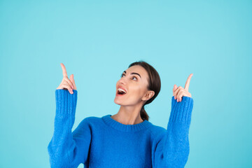 Beauty portrait of a young woman in a blue knitted sweater and natural day makeup, smiling...