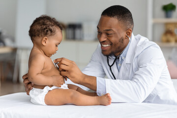 Black Pediatrician Doctor Doing Check Up To Cute Newborn Baby In Diaper - obrazy, fototapety, plakaty