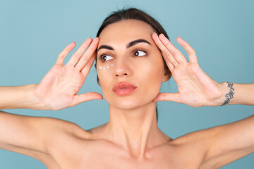 Naklejka premium Close-up beauty portrait of a topless woman with perfect skin and natural make-up, with anti-aging cream dots to moisturize and firm the skin under the eyes