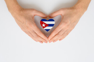 The national flag of Cuba in female hands. The concept of patriotism, respect and solidarity with...