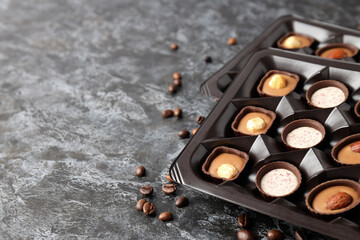 Concept of sweets with chocolate candies on dark textured background