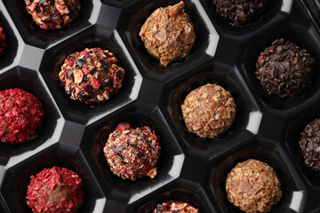 Chocolate candies in box all over background, close up