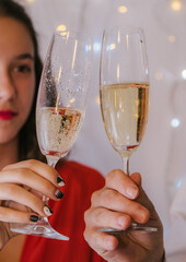 toasting with champagne glasses against holiday lights in new year´s eve. Vertical. High quality photo