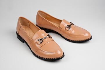 Beige patent leather leatherette shoes with buckle. Close-up shot.