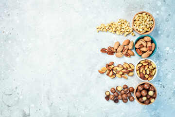 Assortment of nuts: almonds, hazelnuts, cashews and macadamia nuts and pecans. Walnut background. On a stone background.