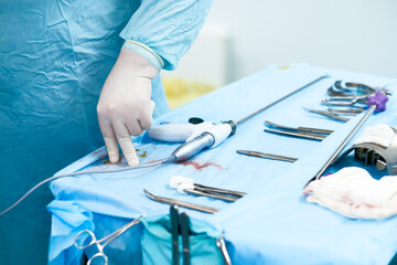 Selective focus on the hand of a surgeon wearing a sterile glove. Sterilized surgical instruments...