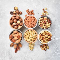 Assortment of nuts: almonds, hazelnuts, cashews and macadamia nuts and pecans. Walnut background. On a stone background.