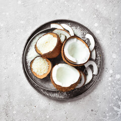 Coconut shavings. Fresh coconuts and coconut flakes. On a stone background. Top peregdyad. Free space for text.
