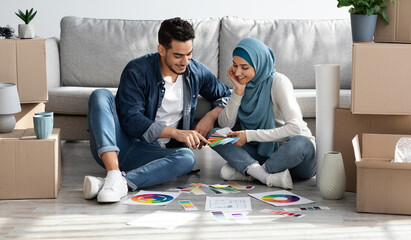 Excited arab couple working on design for new apartment