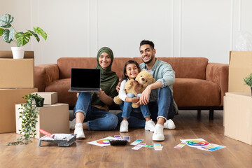 Fototapeta na wymiar Happy muslim family doing repair woman showing laptop
