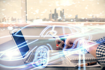 Obraz premium Double exposure of man's hands holding and using a digital device and automobile theme hologram drawing. Technology concept.