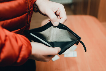 Mans hands checking wallet near desk.close up,toned.Blurred background.Soft focus.