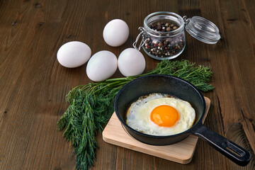 Fried egg in a small skillet with a stand, a bunch of dill