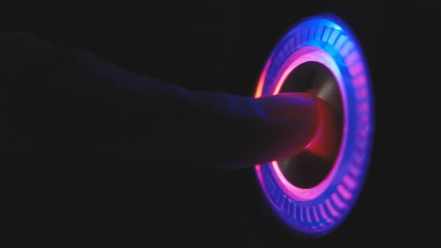 A person's finger presses the computer start button. Illuminating button to turn on the computer on the system unit. 4k macro loop video.