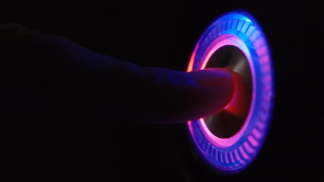 A person's finger presses the computer start button. Illuminating button to turn on the computer on the system unit. 4k macro loop video.