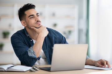 Thoughtful man sitting in office and looking at copy space