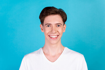 Photo of young cheerful man good mood toothy smile hygiene cavity protection isolated over blue color background