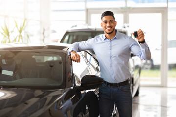 Fototapeta na wymiar Handsome arab man customer holding key from auto, buying car