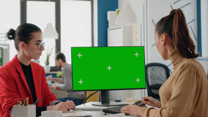 Coworkers working with green screen on monitor for startup business. Women using isolated...