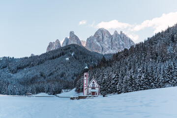 church in the middle of the alps with snow-capped mountains in the background