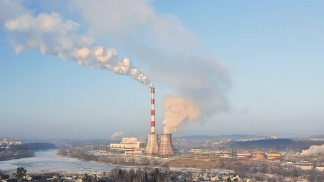 Thermal Heating Plant with White Smokestack pollution and emissions co2 from Coal burning near the city. Human impact on climate change: emissions from thermal power plants that pollute the air.