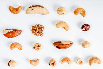 Different nuts are scattered on a white background. Walnuts, hazelnuts and Brazil nuts. The concept of healthy eating and snacking