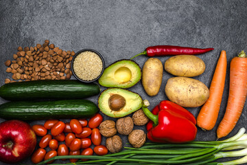 Healthy food background. Healthy vegetarian food. Vegetables and fruits on black stone. Clean vegetarian eating concept.