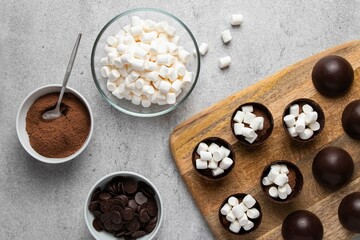 Ingredients for hot cocoa chocolate ball bomb with marshmallow and cooking process. Holiday winter...