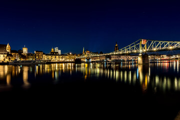 The bridge called Eiserner Steg in Frankfurt - Main at night with view to the city at a cold day in winter.