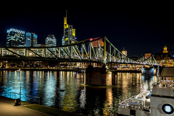The bridge called Eiserner Steg in Frankfurt - Main at night with view to the city at a cold day in winter.
